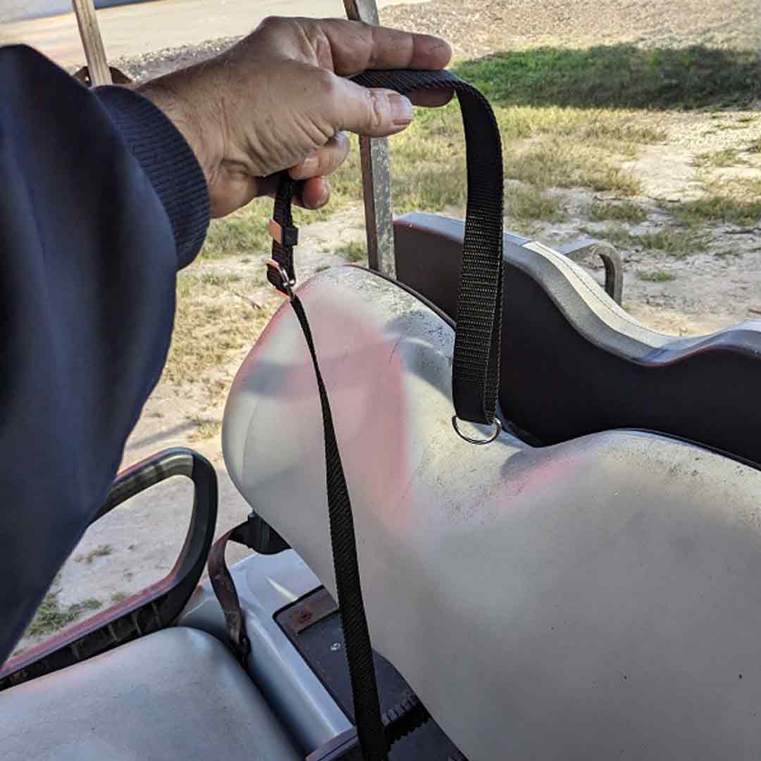 Person attaching tether to golf cart seat